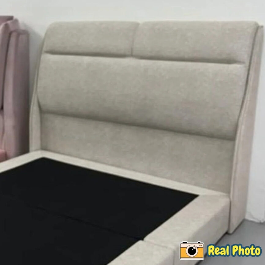 Beige upholstered headboard against a white wall